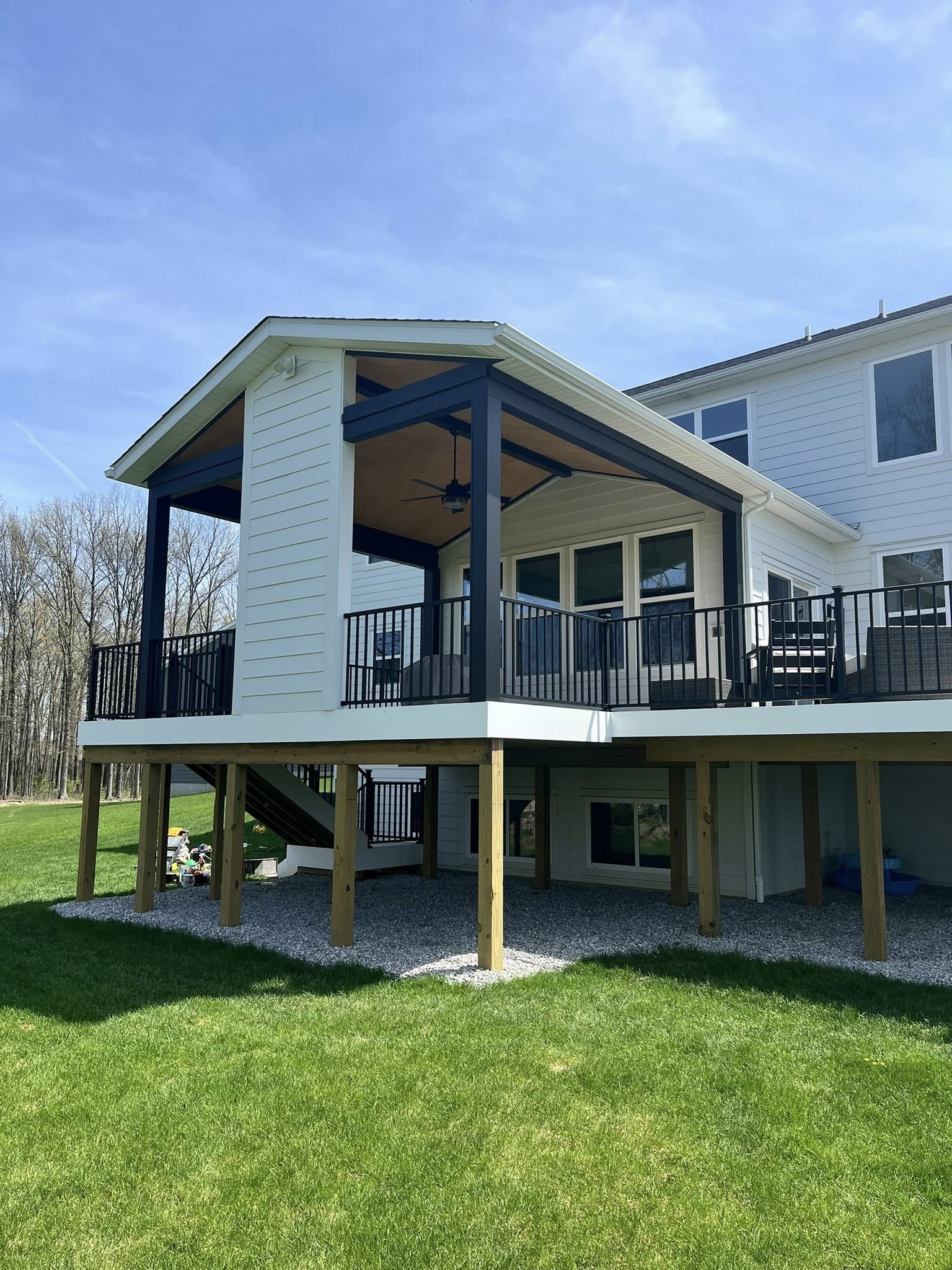 Elevated covered deck with navy trim and white siding