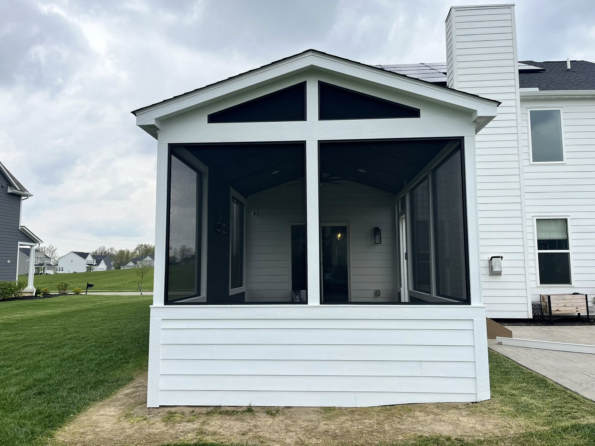 Finished screened porch exterior with white trim and dark screens